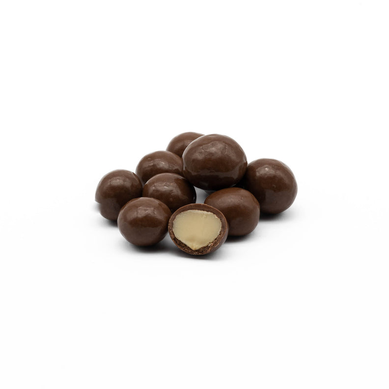 Milk chocolate-covered macadamia nuts, highlighting the glossy chocolate coating and the creamy texture of the nuts inside.