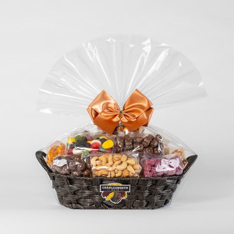  A visually appealing gift basket from Charlesworth Nuts, showcasing a variety of 12 different nuts and chocolates. The basket is elegantly presented on a recyclable base and adorned with a charming orange bow.