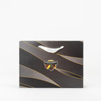 "Black gift bag with gold accents filled with chocolates and nuts"
