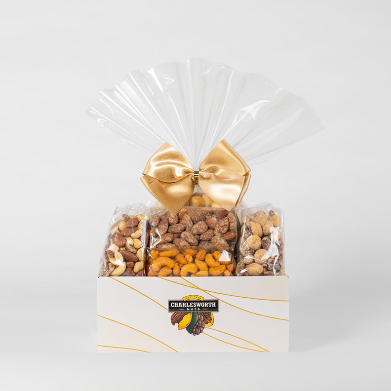 A beautifully arranged gift basket adorned with a gold ribbon, featuring with an assortment of nutritious nuts, promising a delightful treat for any occasion.
